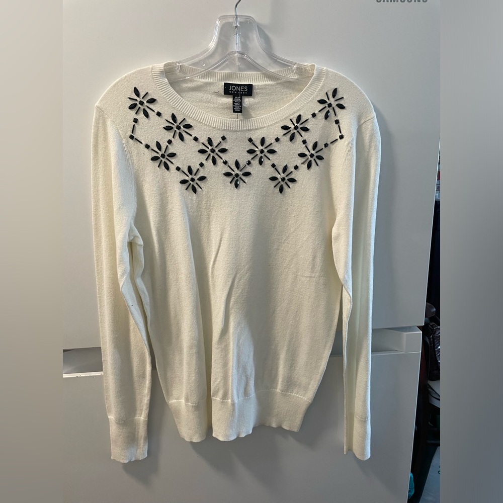 Long sleeve off-white sweater, crewneck with black detailing. Big for its size